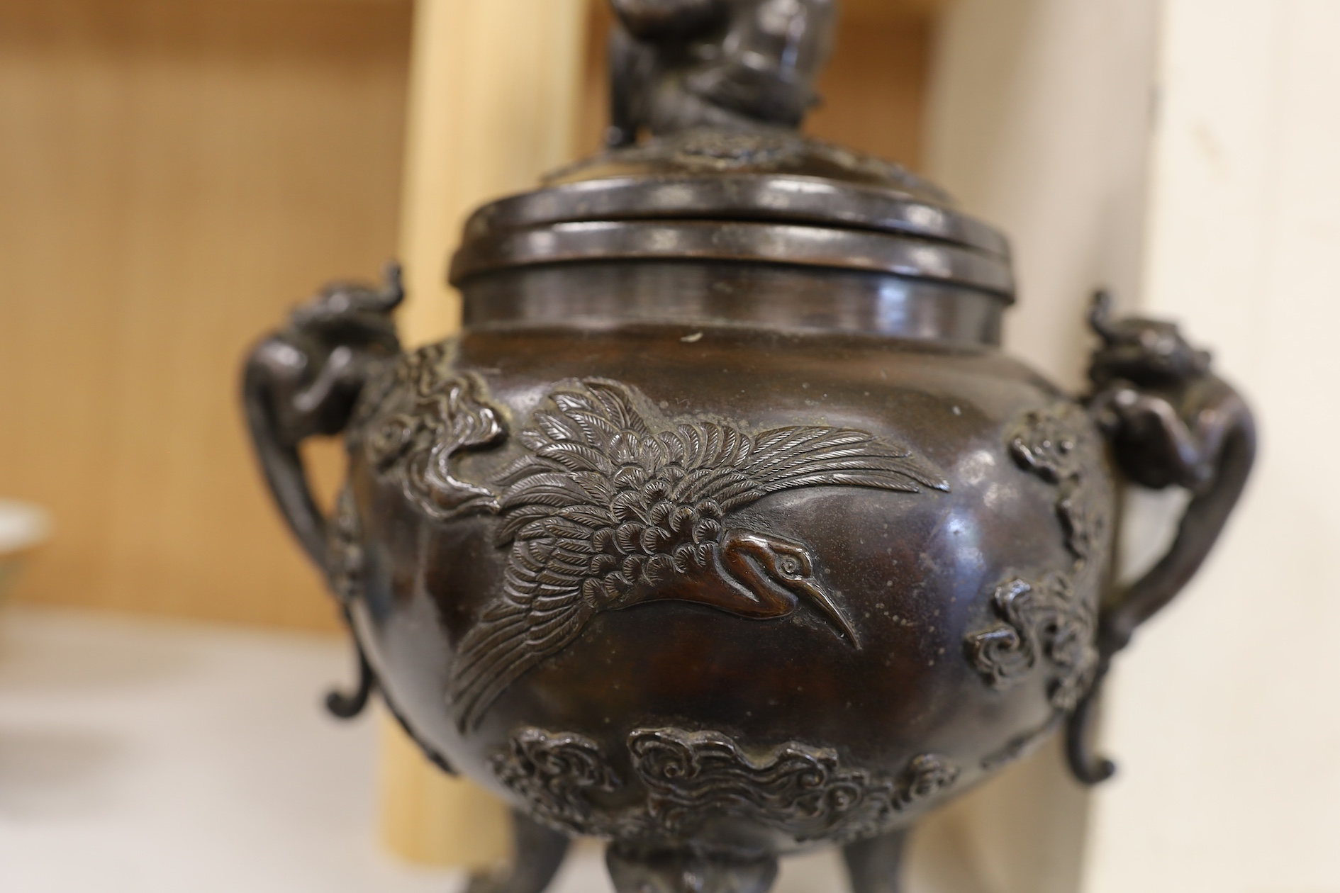 A Japanese bronze dragon handled censer with figural finial to cover, Meiji period, 24cm high. Condition - good